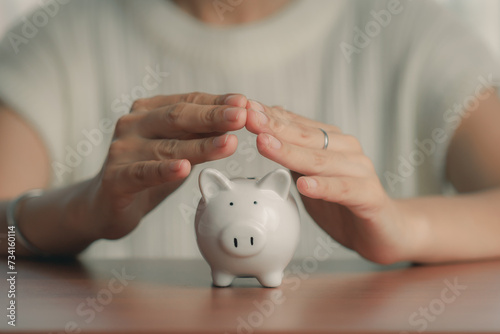 Woman hands covering piggy bank and saving money for savings, investment, and financial wealth in a banking concept