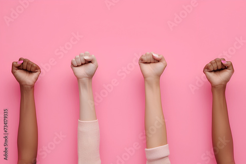 Raised fists of women on a pink background, girl power photo
