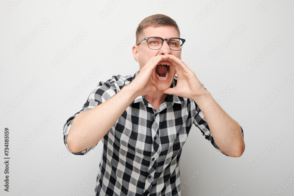 Portrait of handsome man shouting loudly with hands, news, palms folded like megaphone isolated on white background Portrait of handsome man shouting loudly with hands, news, palms folded like megaphone isolated on white background