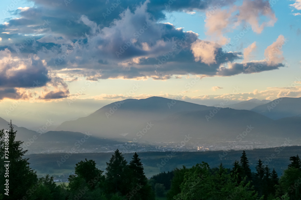 Obraz premium Scenic sunset view of mountain range Bleiberg Erzberg seen from Altfinkenstein, Baumgartnerhoehe, Carinthia, Austria. Tranquility on hiking trail. Overlooking Villach area surrounded by Austrian Alps