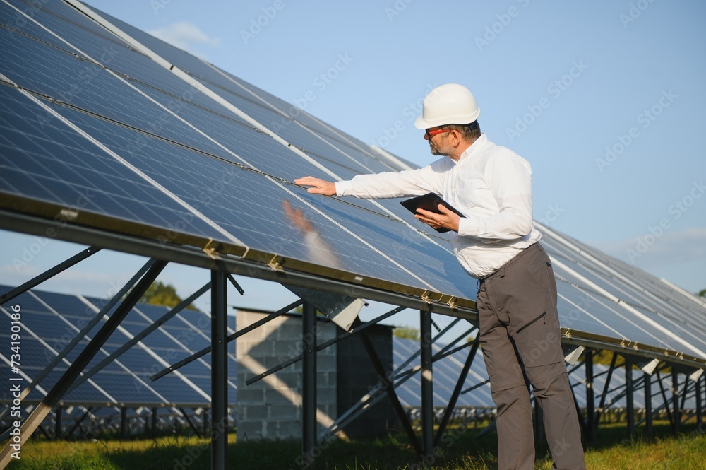 Industrial senior man engineer walking through solar panel field for examination Industrial senior man engineer walking through solar panel field for examination