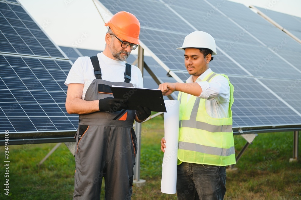 The solar farm(solar panel) with two engineers walk to check the operation of the system The solar farm(solar panel) with two engineers walk to check the operation of the system