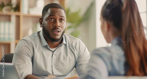 Professional adult Black African American businessman engaged in discussion work plan, strategy, sales report. Employer talking to candidate on job interview, discussing resume.