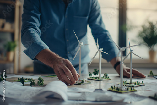 Engineer designing wind turbines and wind farm in the modern office. Eco-friendly technology and engineering of renewable source of energy. Sustainable investments.