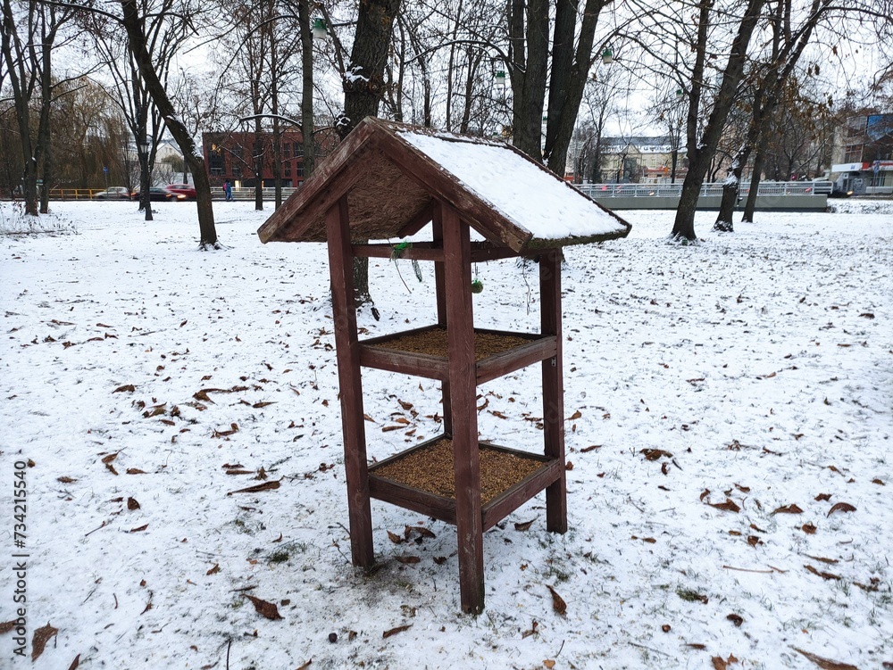 Bird feeder in the winter park in the evening Bird feeder in the winter park in the evening