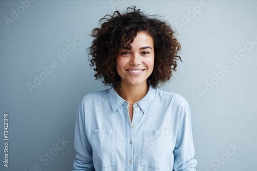 Portrait of a beautiful young woman with curly hair against blue background