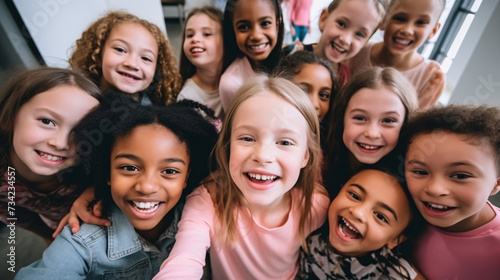 high angle view of smiling multicultural kids looking at camera in school corridor