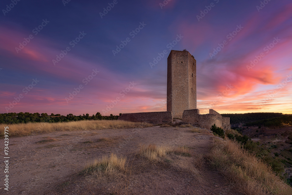 Alarcon weapons tower, Cuenca, at sunset with red clouds on blue sky Alarcon weapons tower, Cuenca, at sunset with red clouds on blue sky