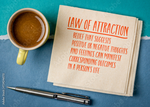 Law of attraction - explanation note on a napkin with coffee, personal growth and motivation concept