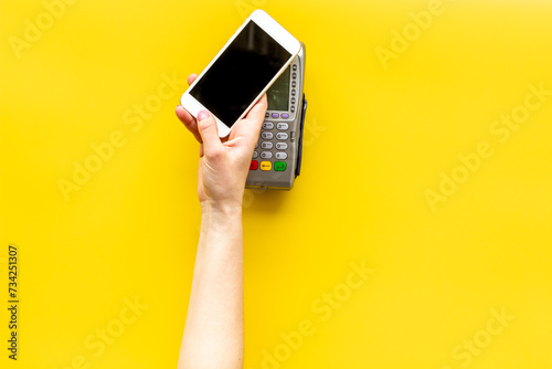 Female hand with mobile phone near POS payment terminal. Payment by mobile pay © 9dreamstudio