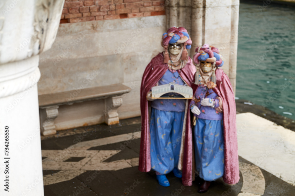 Venice, Italy - February 2022 - carnival masks are photographed with tourists in San Marco square Venice, Italy - February 2022 - carnival masks are photographed with tourists in San Marco square