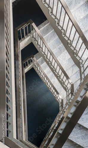 Geometric metal staircase with white marble treads in an office building