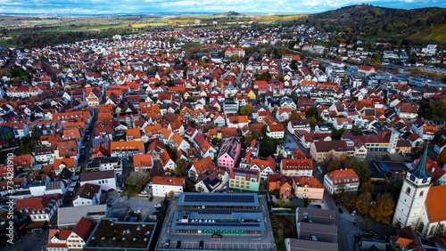 Aerial around the old town of the city Metzingen in Germany on a afternoon in autumn. 