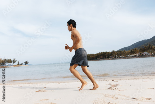Active Asian Athlete Embracing Fitness on Sandy Beach: A Meditative Stretching Session