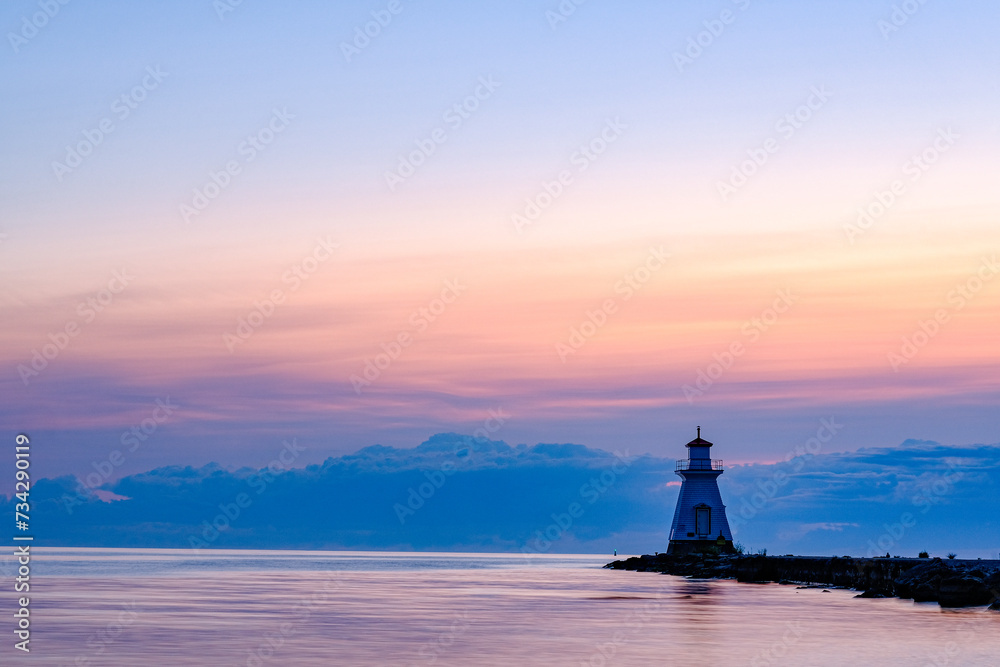 Beautiful pink and blue sunset at the lake with lighthouse view