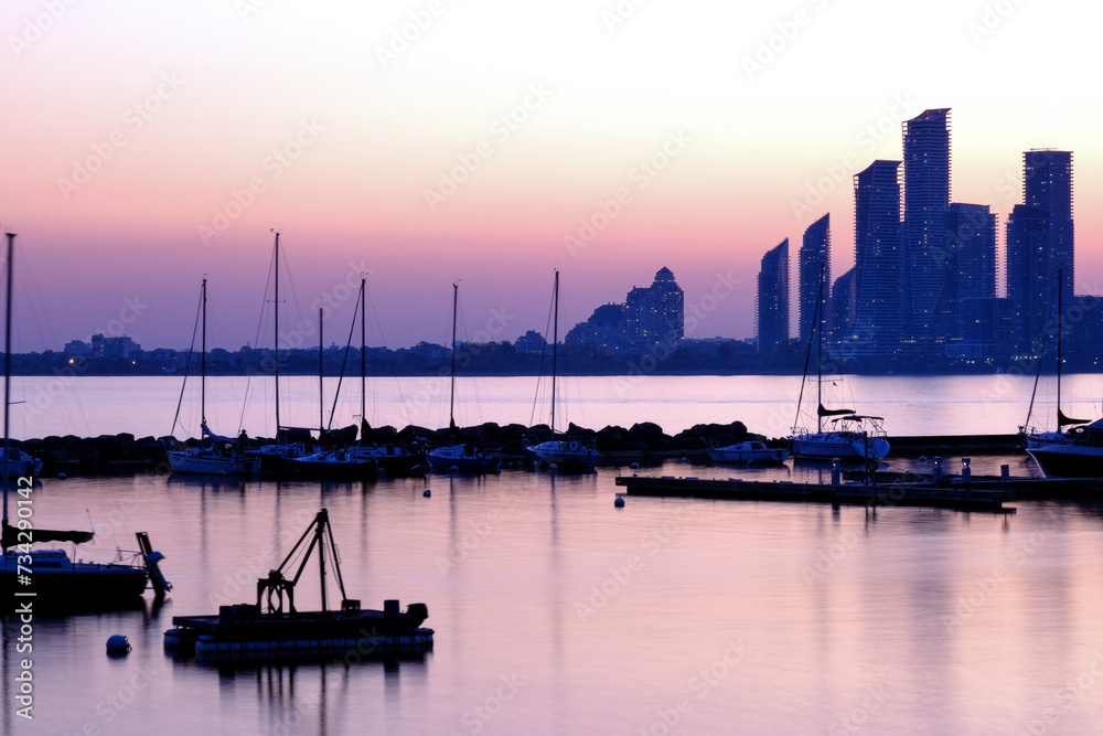 Fototapeta premium Boats in the bay sunset over Etobicoke modern new skyline