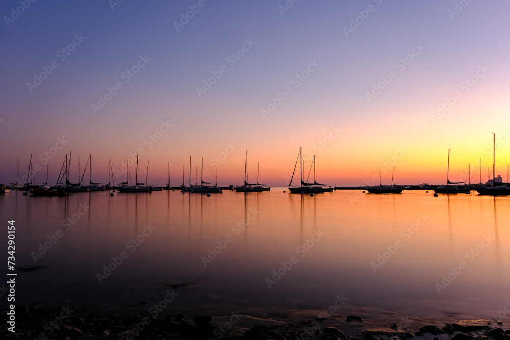 Sunset at the marina harbor with many boats