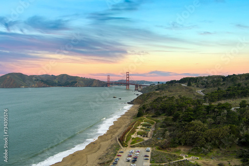 Wallpaper Mural aerial shot of the Golden Gate Bridge and the blue waters of the bay with lush green trees, plants and grass along the hillside and people on the beach in San Francisco California USA Torontodigital.ca