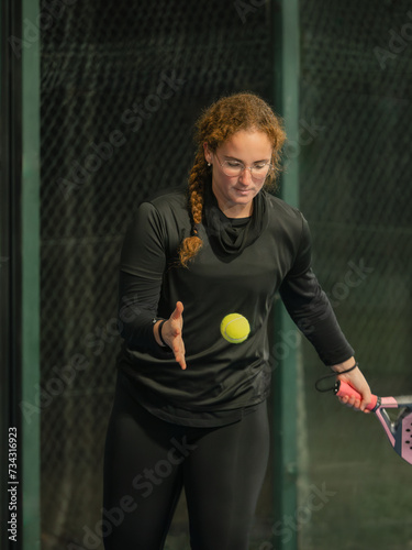 Young Woman Padel Player Serving on an outdoor Court © Hodayfa
