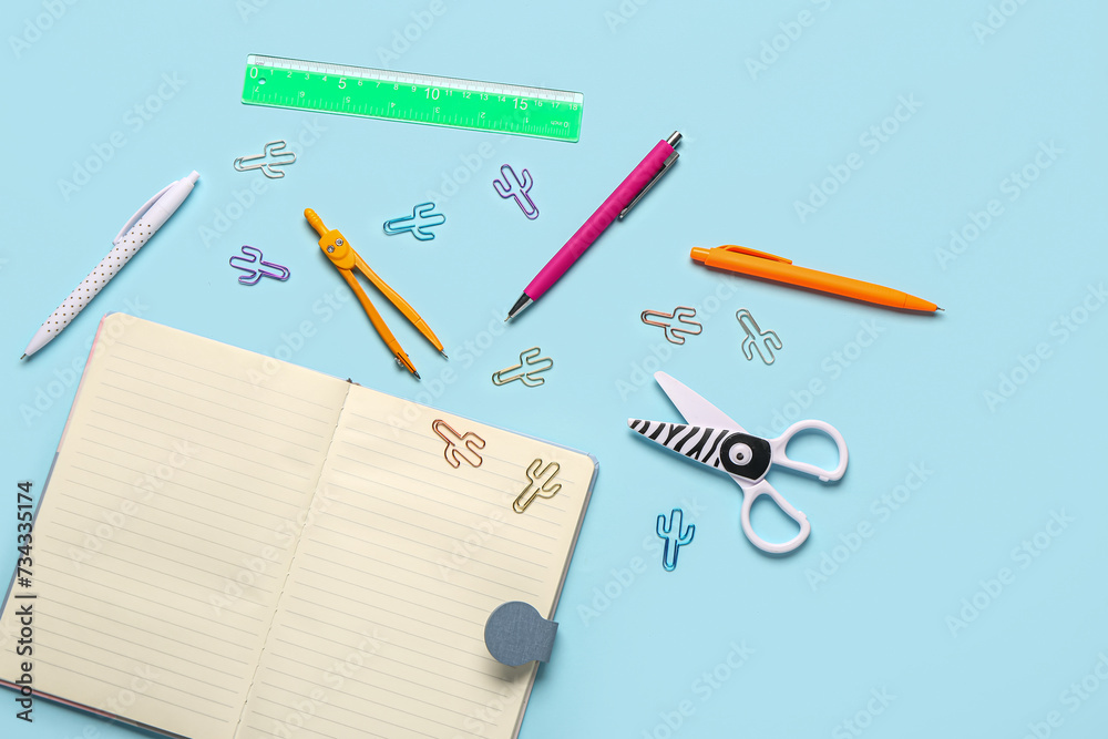 Notebook with different stationery supplies on blue background Notebook with different stationery supplies on blue background