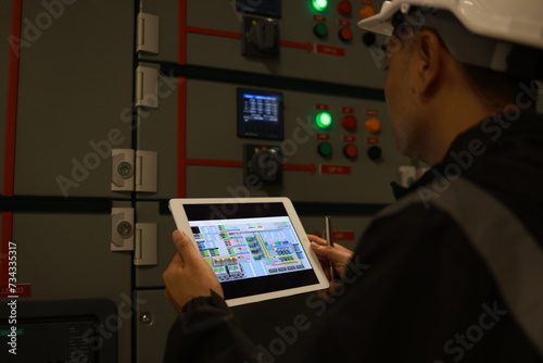 The electrical inspector engineer checking the status multimeter of the distribution board load panel at the factory