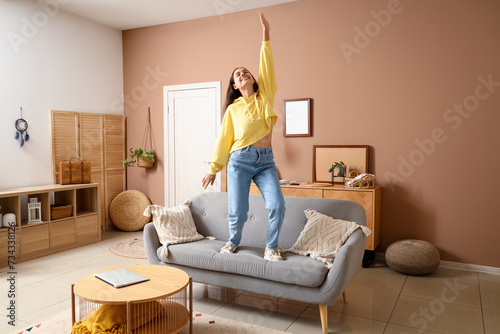 Young woman in hoodie danci...