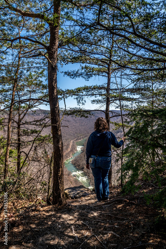 Woman Hiker Admiring Canyon River View Through Forest Trees at New River Gorge National Park