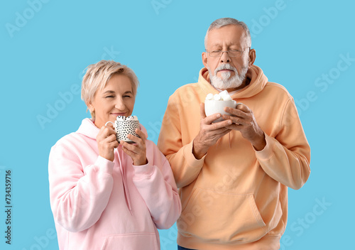 Mature couple with cups of ...