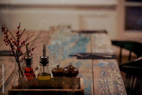 On a wooden table there is a set with spices and olive oil.