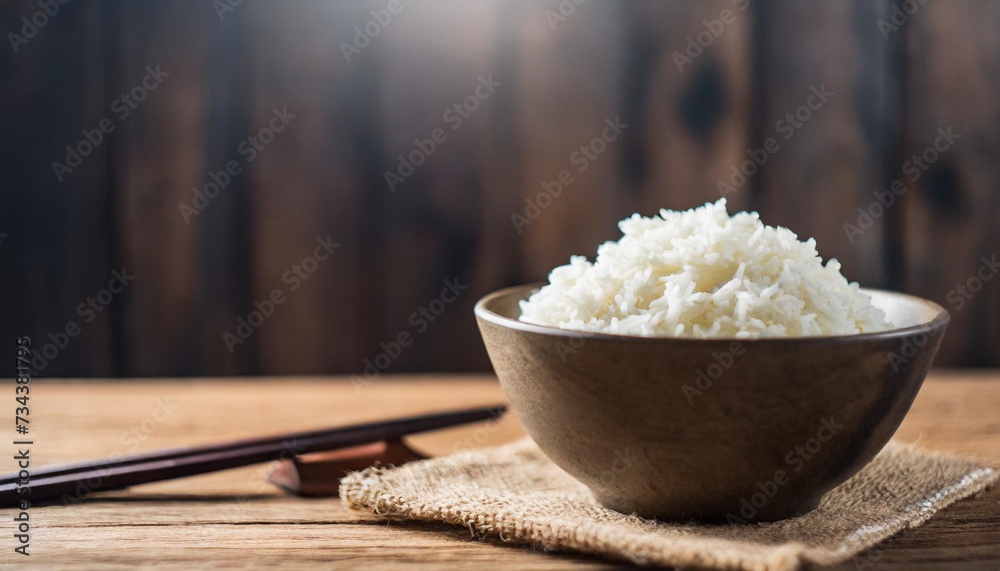 Cooked rice in bowl on wooden background, symbolizing nutrition, sustenance, Asian cuisine. Copy space for food-related concepts Cooked rice in bowl on wooden background, symbolizing nutrition, sustenance, Asian cuisine. Copy space for food-related concepts