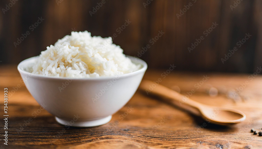 Cooked rice in bowl on wooden background, symbolizing nutrition, sustenance, Asian cuisine. Copy space for food-related concepts Cooked rice in bowl on wooden background, symbolizing nutrition, sustenance, Asian cuisine. Copy space for food-related concepts