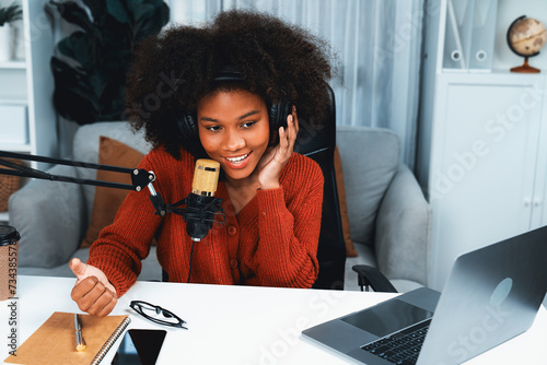 Host channel of beautiful African woman influencer talking with new listeners in broadcast studio. Time slot of life coach consultant on live social media online. Concept of giving advice. Tastemaker. photo