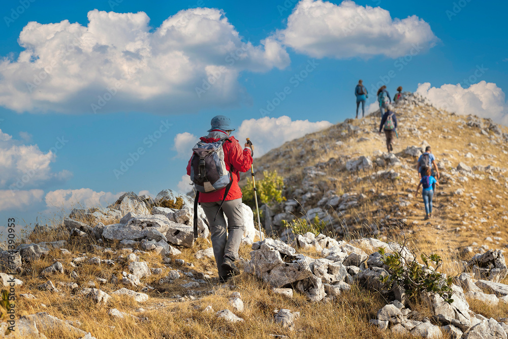 Fototapeta premium A group of hikers reaches the top of a mountain