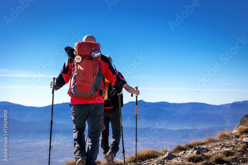 Two hikers reaches the top of a mountain