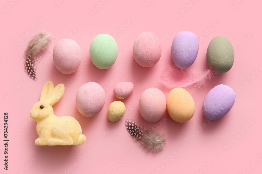 Painted Easter eggs with feathers and bunny on pink background Painted Easter eggs with feathers and bunny on pink background