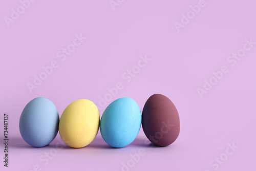 Painted Easter eggs on purple background