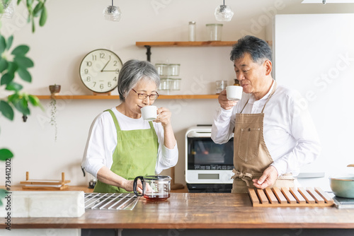 キッチンでコーヒーを飲むアジア人高齢者夫婦（笑顔）
 photo