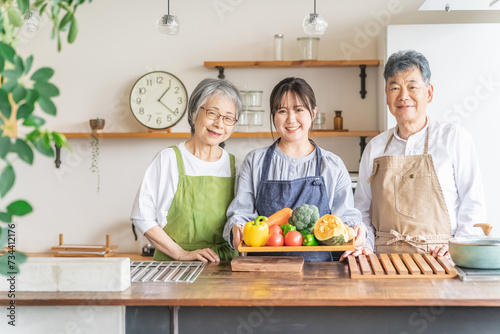野菜を持つ高齢者夫婦と若い日本人（栄養士・家事代行・介護）
 photo