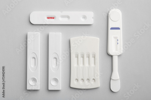 Different disposable express tests on light grey background, flat lay
