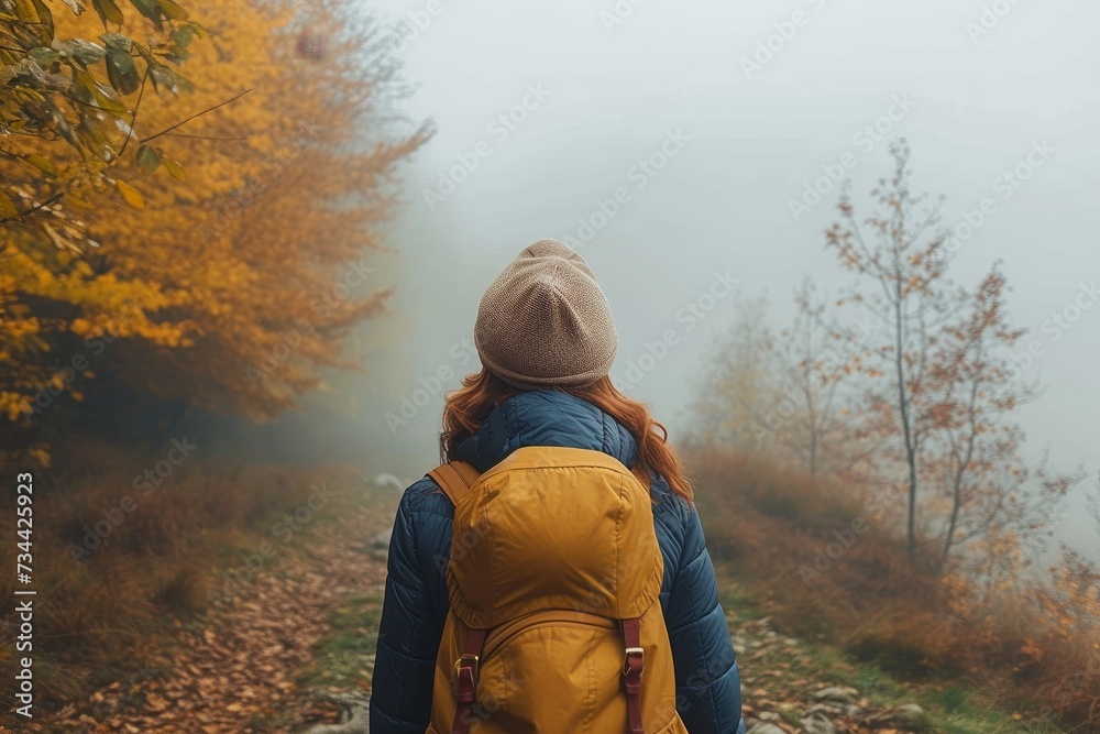A solitary figure braves the chilly autumn air, surrounded by the mystical embrace of fog and towering trees on her journey through the enchanted forest A solitary figure braves the chilly autumn air, surrounded by the mystical embrace of fog and towering trees on her journey through the enchanted forest