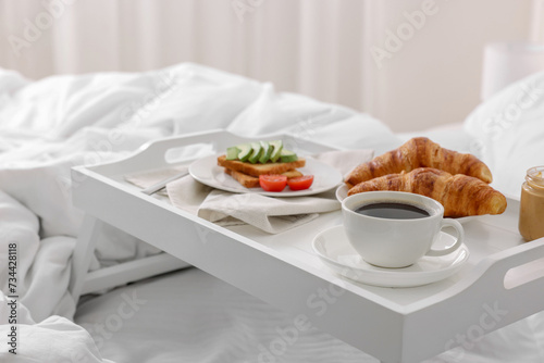 Good morning. Tray with tasty breakfast on bed at home