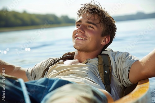 A contented man drifts along the serene lake, his face glowing with a smile as he sails in his canoe, basking in the warm summer sky