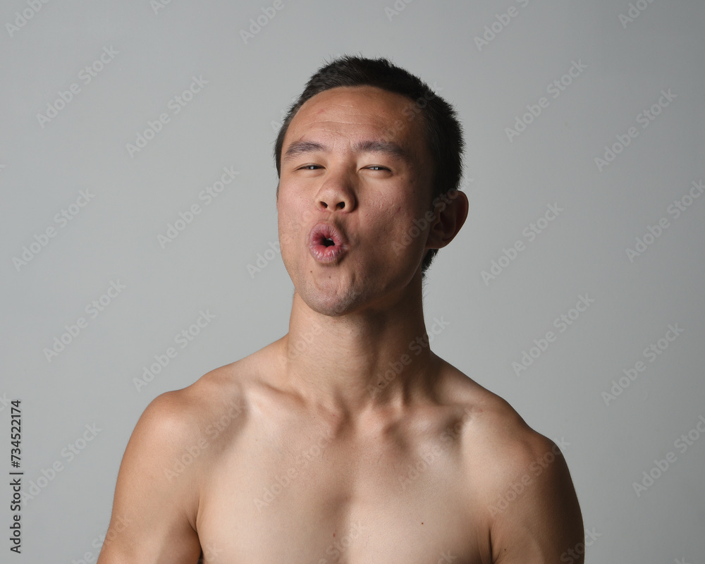 Close up portrait of asian male model, expressive and exaggerated facial expressions and silly faces. Isolated on a white studio background Close up portrait of asian male model, expressive and exaggerated facial expressions and silly faces. Isolated on a white studio background