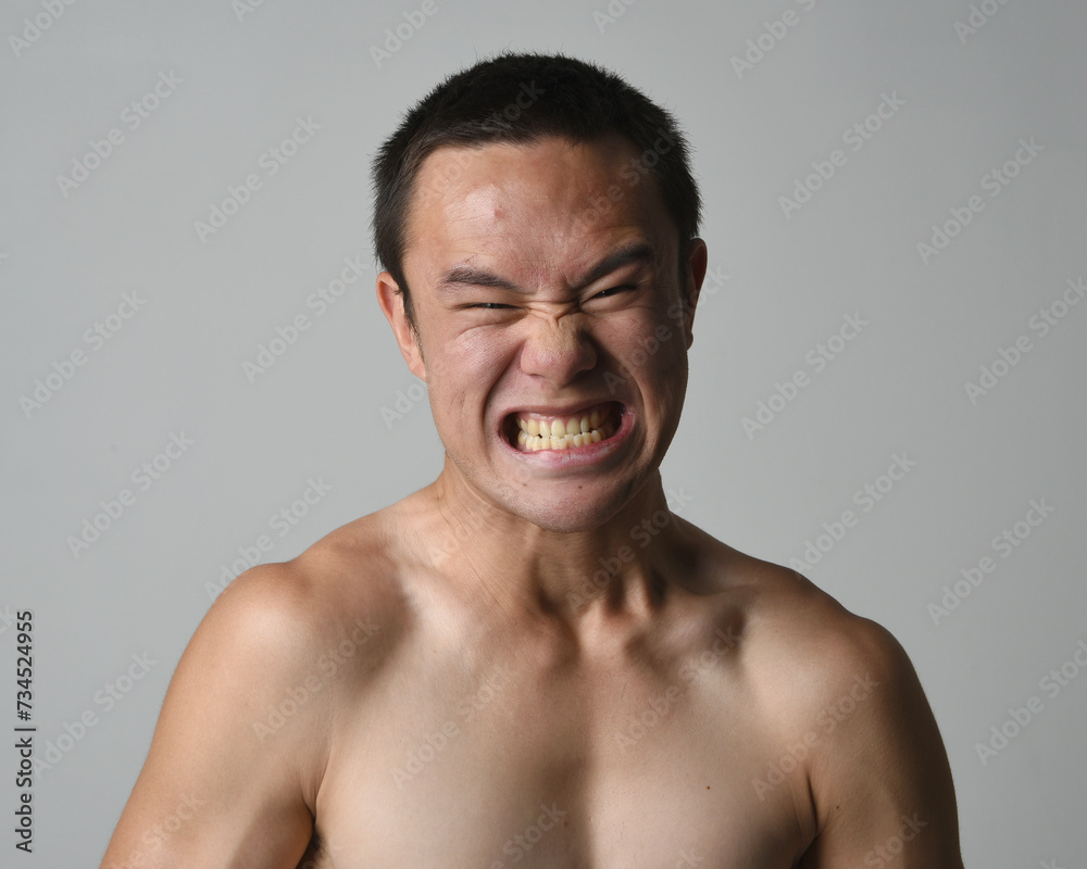 Close up portrait of asian male model, expressive and exaggerated facial expressions and silly faces. Isolated on a white studio background Close up portrait of asian male model, expressive and exaggerated facial expressions and silly faces. Isolated on a white studio background