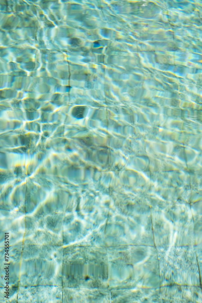 Obraz premium Sunshine through the ripples of water in swimming pool.
