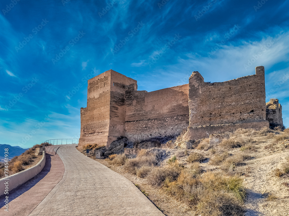 Medieval Jumilla castle with large keep circular tower on a hilltop in Spain with blue sky