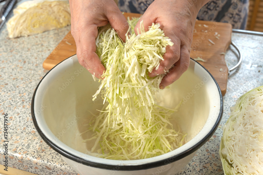 Thinly sliced white cabbage for making salad. Homemade food. Veganism and raw food diet concept. Thinly sliced white cabbage for making salad. Homemade food. Veganism and raw food diet concept.