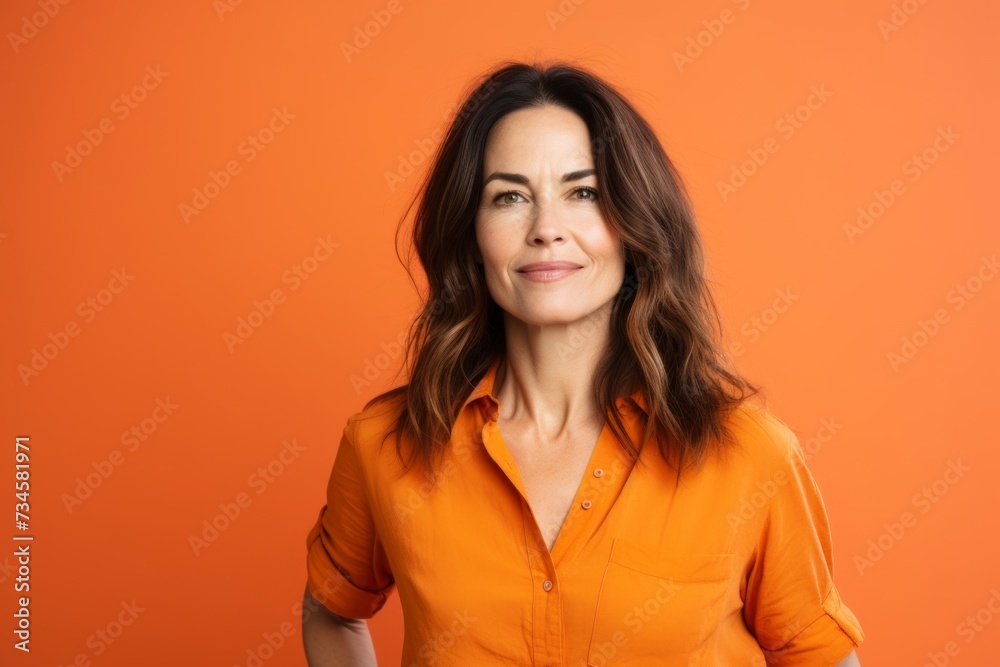 Portrait of a beautiful young woman in orange shirt on orange background Portrait of a beautiful young woman in orange shirt on orange background