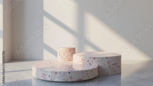 Elegant terrazzo style display podiums bathed in soft natural light against a white backdrop.
