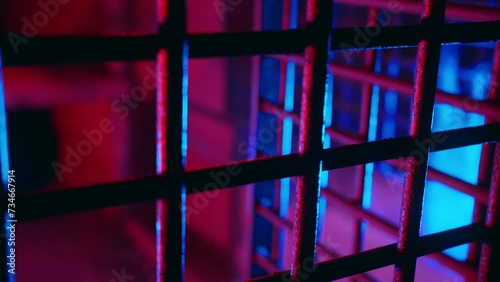 Cinematic metal bars in scary dungeon cell for torture. Abandoned prison. Creepy cage underground. Thriller jail lit with ambient red and blue neon light. Ancient underground chamber. Old prison grate photo